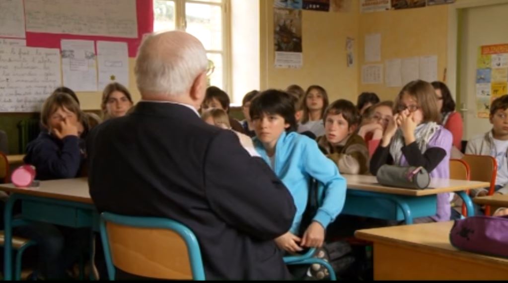 Un homme raconte son histoire devant des enfants en classe