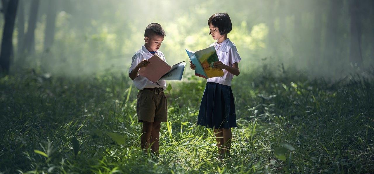 Deux enfants lisant dans la nature