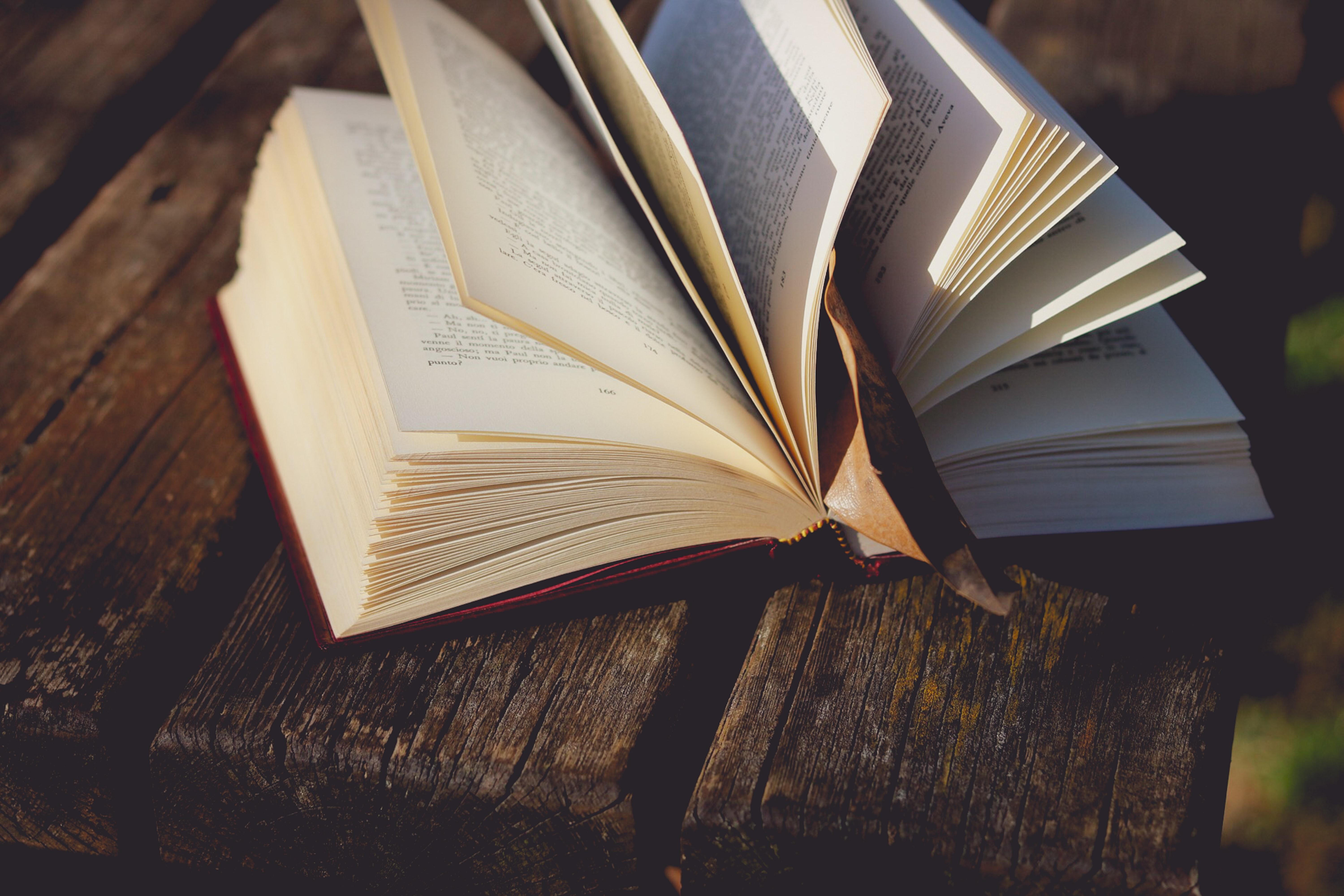 Photographie d’un livre ouvert sur une table de bois